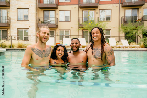 Portrait of friends smiling hugging in pool  © Inti St. Clair