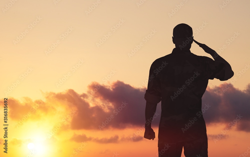 Young military soldier man silhouette on sunset background