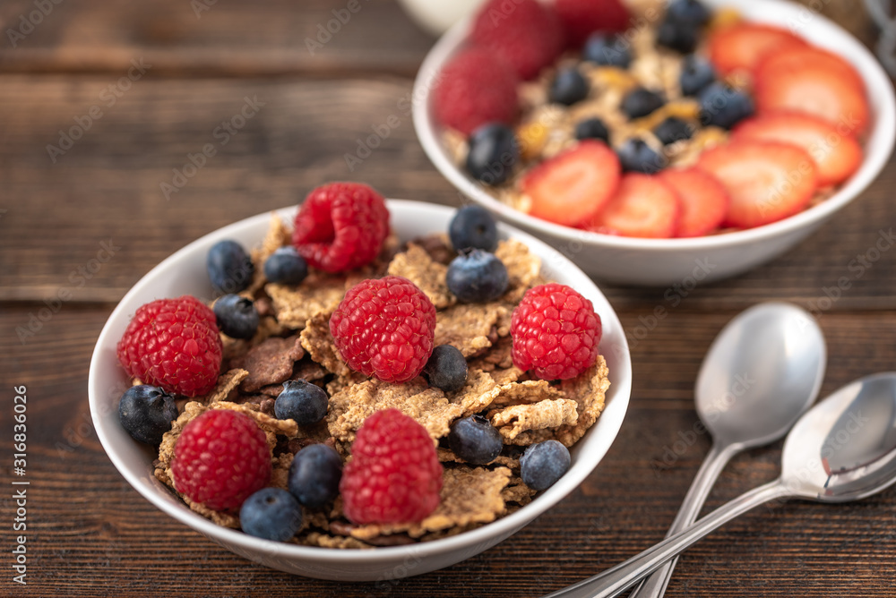 Granola chips with blueberries and raspberries in white bowl. Granola chips with blueberries and raspberries in white bowl.