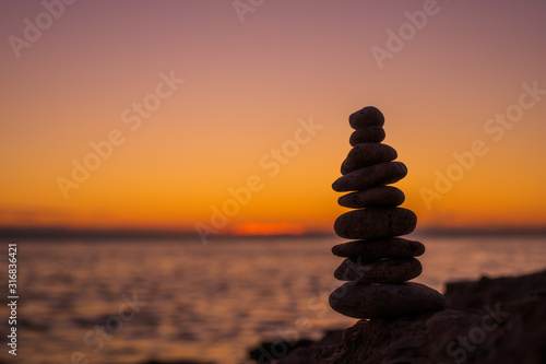 The object of the stones on the beach at sunset. Zen concept. Sunset. Silhouette of stones against the sunset sky