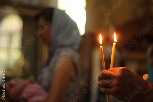 Fototapeta orthodox church, baptism of a child, burning candles