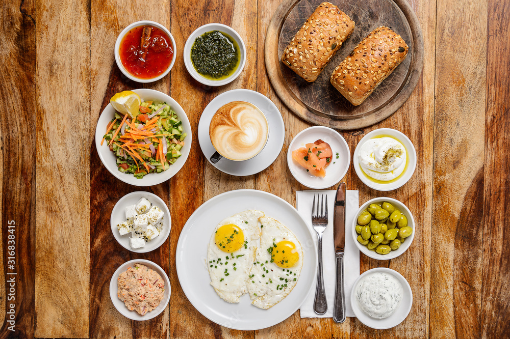 Classic breakfast with a cup of cappuccino and meals on wood background Classic breakfast with a cup of cappuccino and meals on wood background