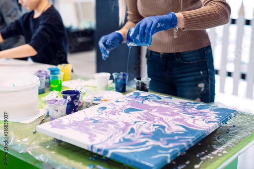 People of all ages are fond of drawing. Acrylic paint flows over the canvas. chaotic drawing.