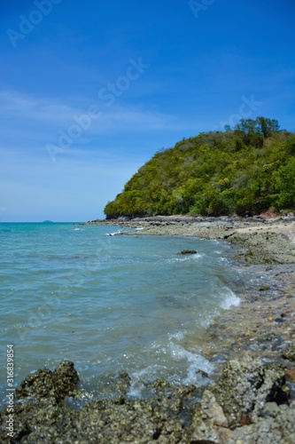 Beautiful rock beach with sea ocean and mountain blue sky landscape background,An island in the sea with beaches, rocks and turquoise water in the hot summer sun of Thailand.