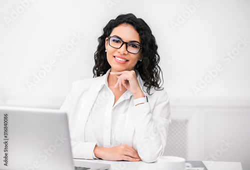 Foto Mexican recruiter looking at camera with hand on chin
