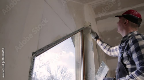 home improvement handyman filling drywall with filler in new build attic