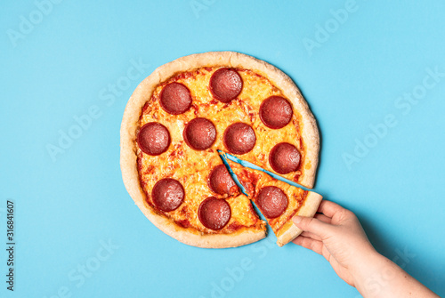 Pizza pepperoni and taking a slice of pizza. Eating pizza salami