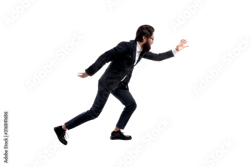 full length portrait of bearded, trendy businessman running isolated on white background, man pulls hand forward to catch something
