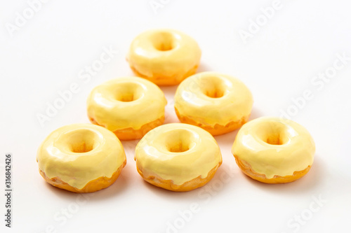 Group of donuts with yellow icing on a white background. High-calorie food.Dessert. National Doughnut Day, Sweetest Day.