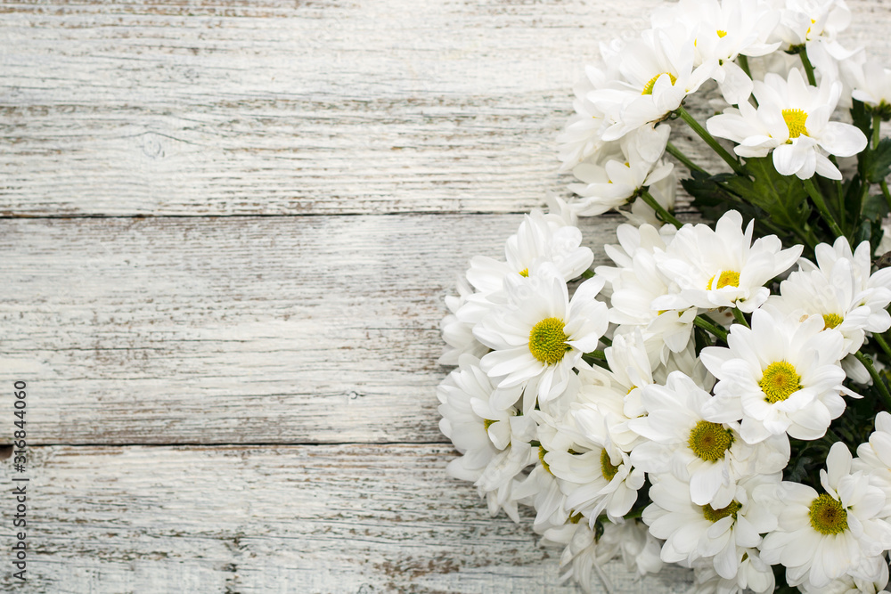 Obraz premium bouquet of daisies on a white wooden background