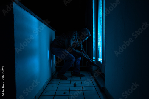 Einbrecher in der Dunkelheit mit Brecheisen