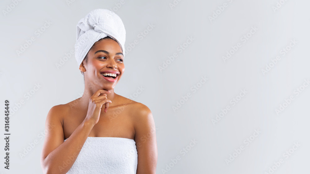 Happy black woman wrapped in towels looking at copy space Happy black woman wrapped in towels looking at copy space