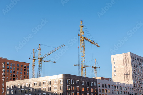 Inside place for many tall buildings under construction and cranes under a blue sky
