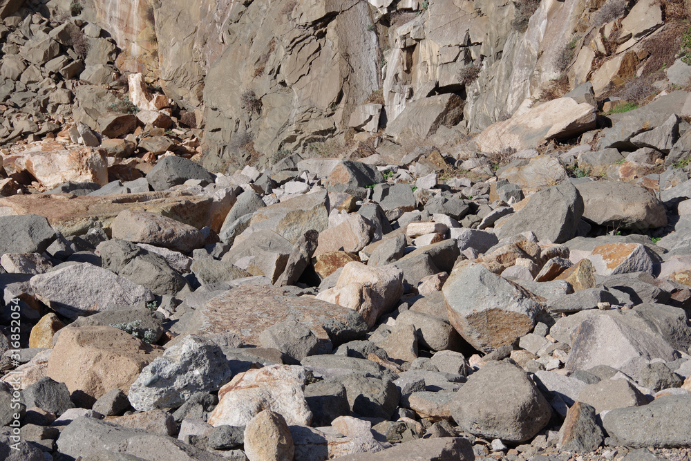 Close-up view of fallen heavy rocks at a steep mountain side