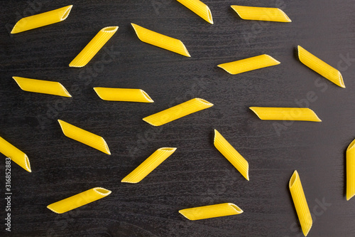 Pattern of A pile of penne pasta on black background