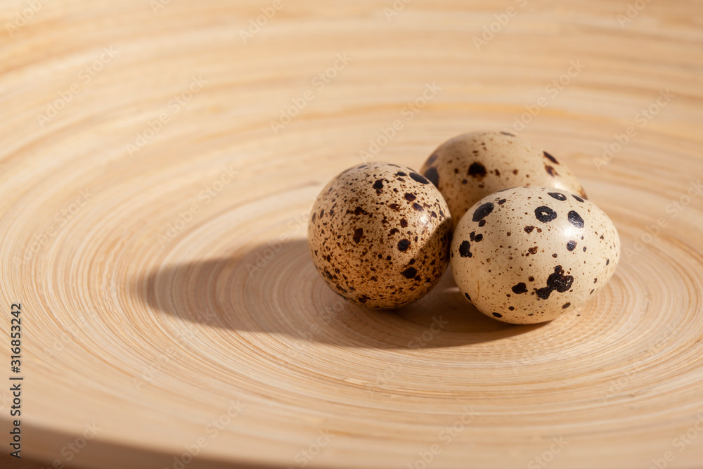 Quail eggs stacked on a yellow bamboo plate. Quail eggs stacked on a yellow bamboo plate.