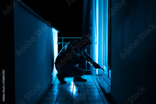 Einbrecher in der Dunkelheit mit Brecheisen photo