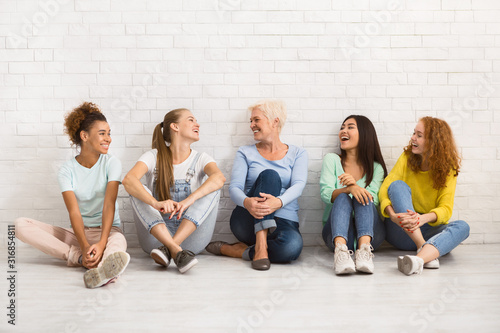 Diverse Women Sitting On Floor Talking And Smiling Indoor