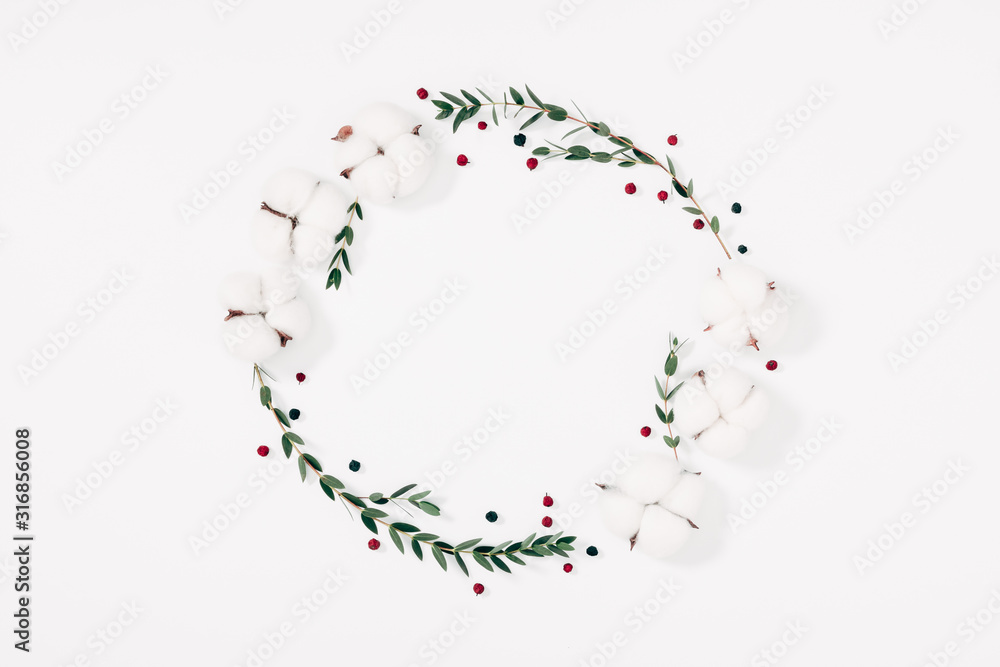 Modern composition of flowers and eucalyptus. Pattern made of eucalyptus branches and leaves, cotton flowers on white background. Flat lay, top view, copy space