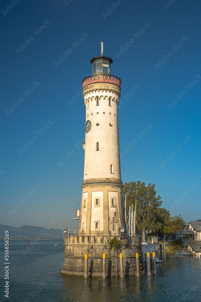 Historic lighthouse in the harbor of Lindau, Bavaria. A city in Germany, on an island in the middle of Lake Constance. Alps in the background