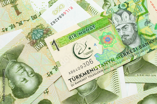 A one manat bank note from Turkmenistan close up in macro with an assortment of Chinese one yuan bank notes.