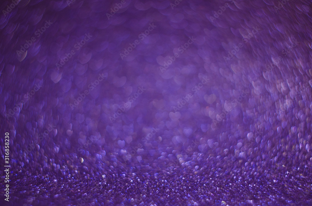 Obraz premium Abstract New Year violet bokeh background with shining defocus sparkles. Blurred glitters shimmering dust macro close up, copy space for text logo