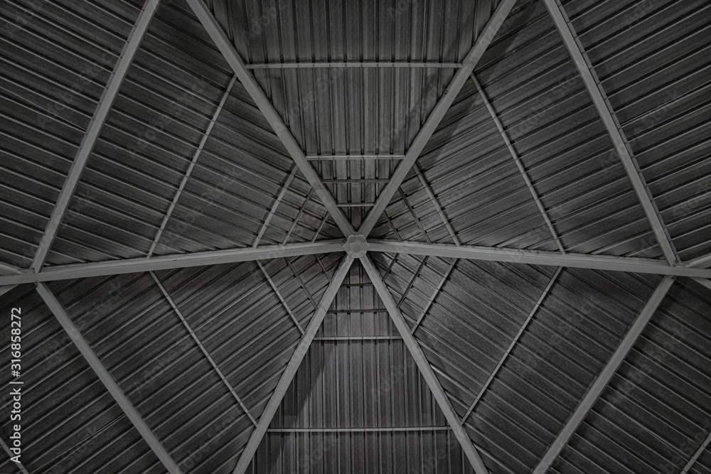 Round and symmetrical pergola dome, roof of a catholic church on Saloum island in Senegal, Africa. It is a gray tin background.