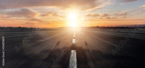 Empty airplane runway with dramatic sunset