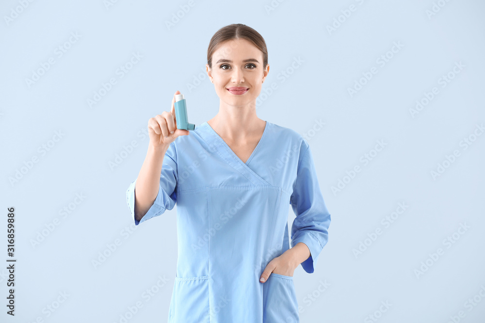 Portrait of female doctor with inhaler on light background Portrait of female doctor with inhaler on light background
