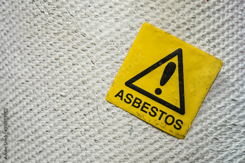 Asbestos warning sign on a pipeline.