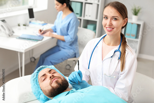Plastic surgeon applying ma...