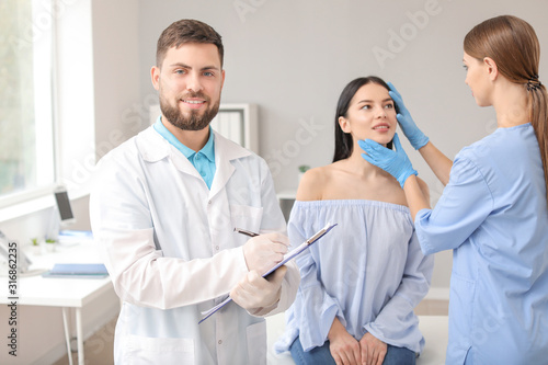 Male plastic surgeon with assistant and patient in clinic © Pixel-Shot