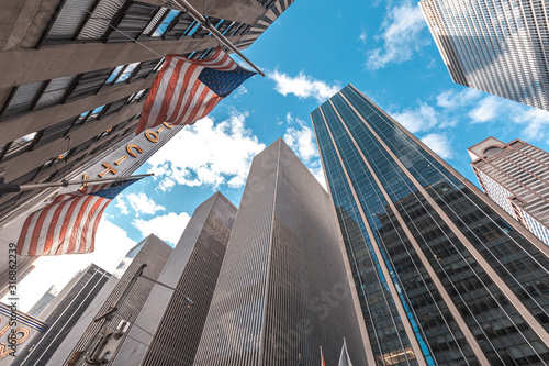 New York, United States »; January 5, 2020: Skyscrapers in Manhattan with American flags and sky above