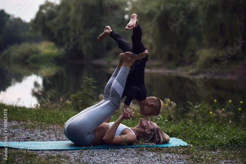 mother and son doing yoga (sports exercises), have fun and spend a good time together in the park. the concept of a healthy lifestyle