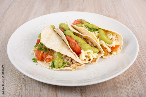 Mexican tacos with chicken, vegetables and guacamole