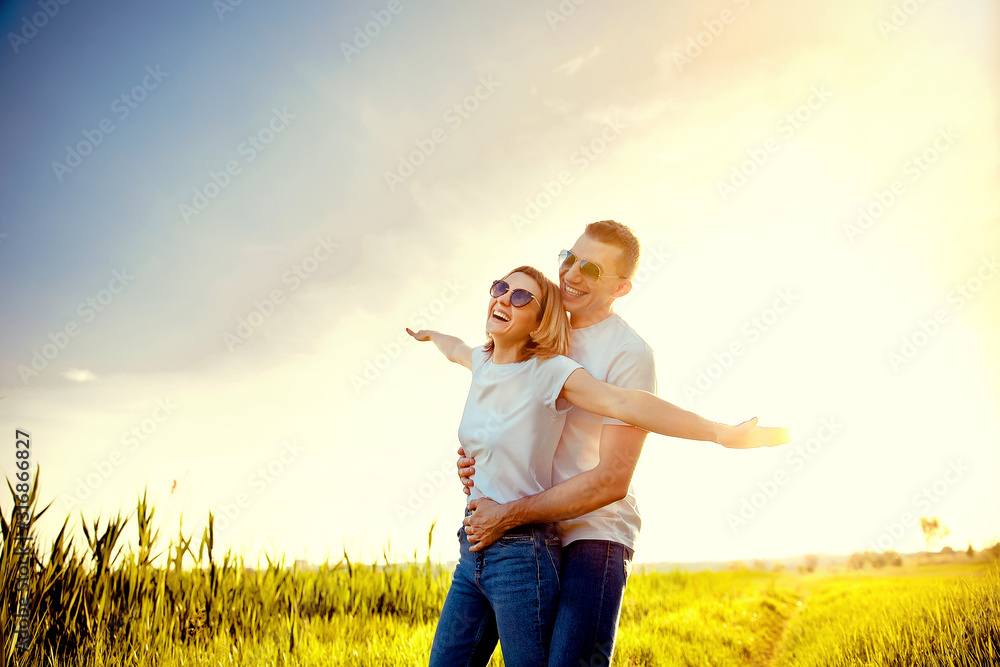 wonderful young couple hug and enjoy life together with natural outdoor laisure activity lifestyle at the beach during the summer and the sunset in backlight. blonde and black caucasian man and woman. wonderful young couple hug and enjoy life together with natural outdoor laisure activity lifestyle at the beach during the summer and the sunset in backlight. blonde and black caucasian man and woman.