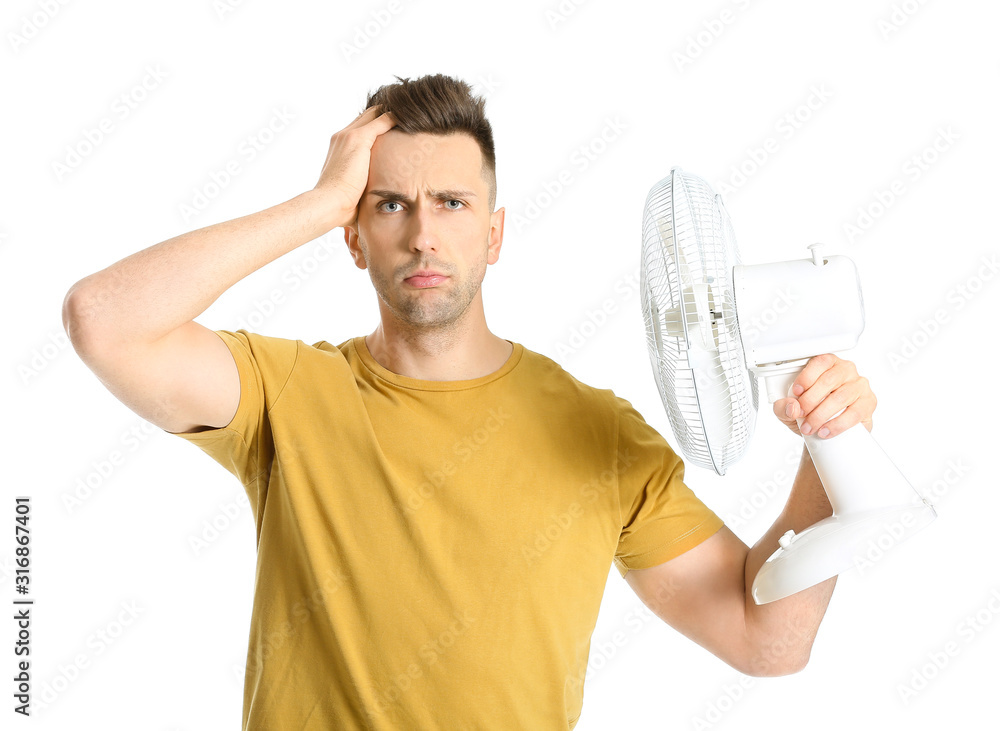 Confused man with electric fan on white background Confused man with electric fan on white background