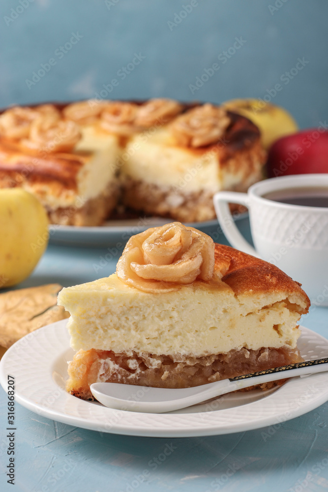 Cheesecake with apples located on a light blue background, decorated with roses from apples and cup of tea, Vertical orientation Cheesecake with apples located on a light blue background, decorated with roses from apples and cup of tea, Vertical orientation