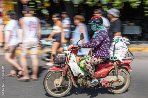 Panning motion shot of commuter in Hoi An, Vietnam.