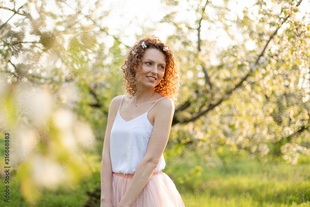 Young attractive girl walks in spring green park enjoying flowering nature. Healthy smiling girl spinning on the spring lawn. Allergy without Young attractive girl walks in spring green park enjoying flowering nature. Healthy smiling girl spinning on the spring lawn. Allergy without