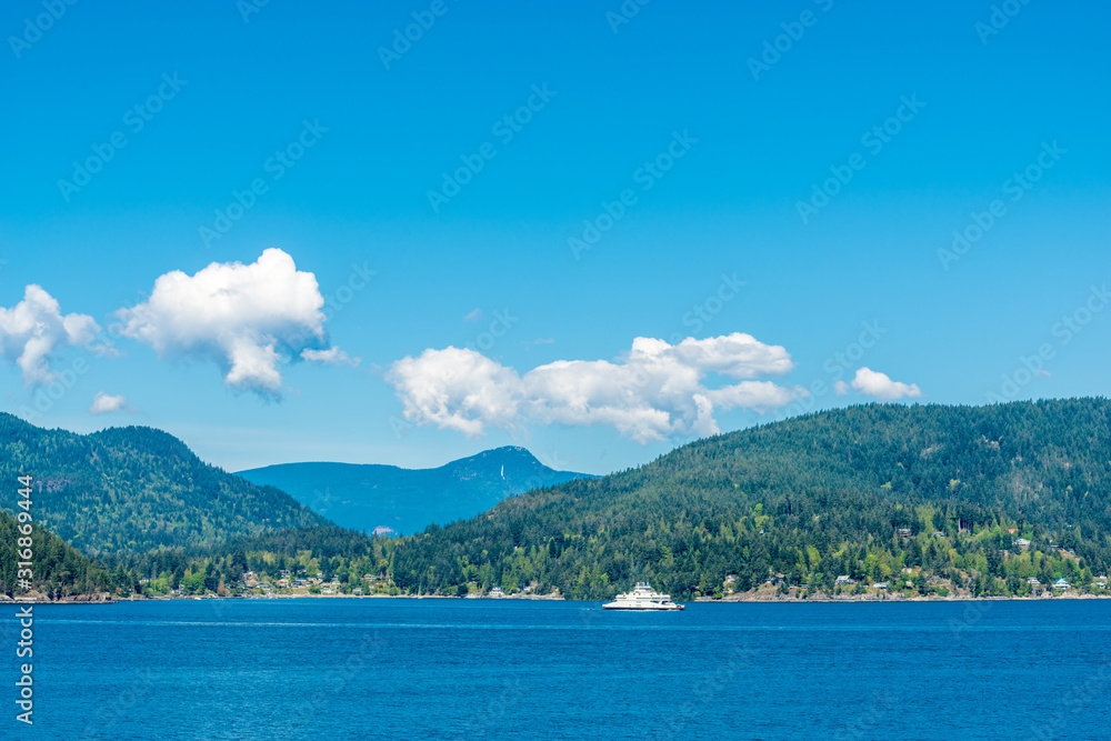 View over inlet, ocean and island with boat and mountains in beautiful British Columbia. Canada.