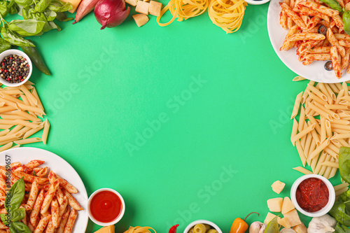 Frame made of boiled and raw pasta with products on color background
