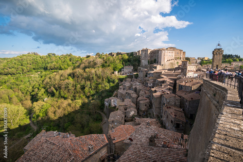 Panoramic view of small vilage in Italy with red brick houses and towers and nature in Sovana Sorano with beautiful sky with clouds in Lazio region Viterbo province in Italy