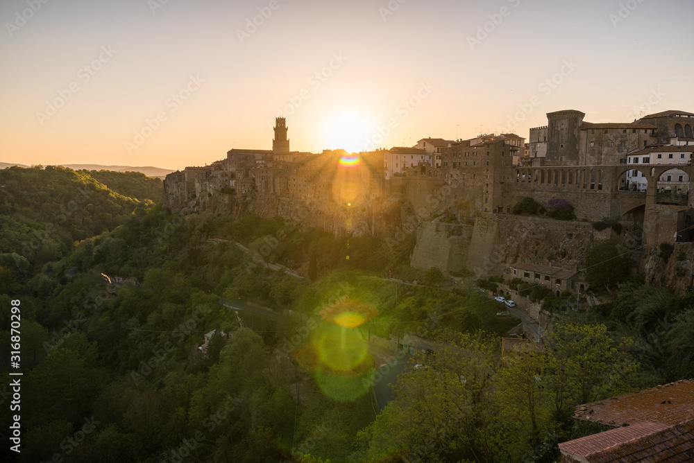 Fototapeta premium Panoramic view of small vilage in Italy with red brick houses and towers and nature at golden hour with beautiful sky clouds in Grosse province in Tuscany Italy during sunset and warm light
