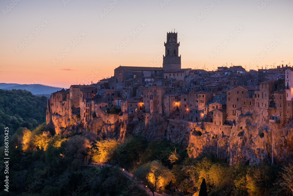 Panoramic view of small vilage in Italy with red brick houses and towers and nature at golden hour with beautiful sky clouds in Grosse province in Tuscany Italy during sunset and warm light