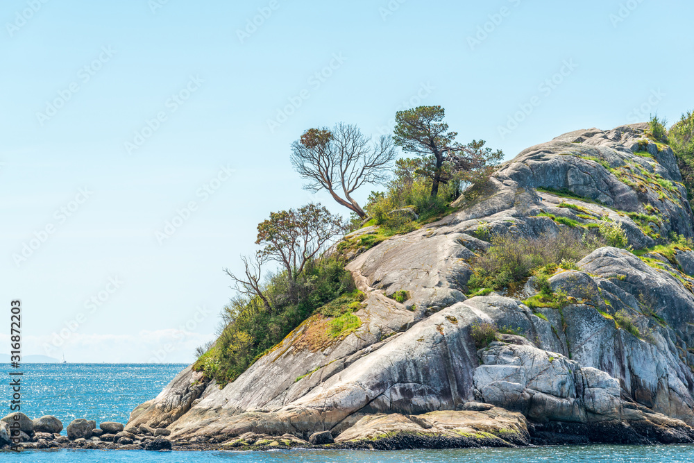 Fototapeta premium View over inlet, ocean and island with boat and mountains in beautiful British Columbia. Canada.
