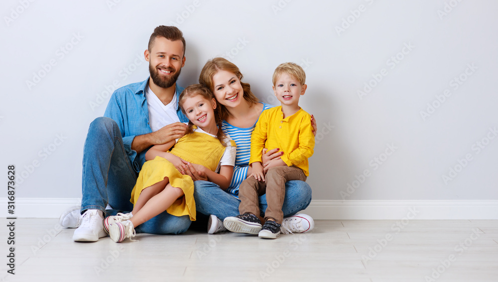happy family mother father and children daughter and son  near an empty   blank wall