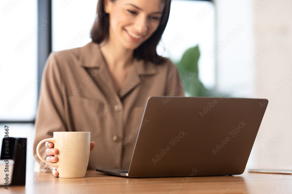 Smiling woman working on personal computer at cafe Smiling woman working on personal computer at cafe