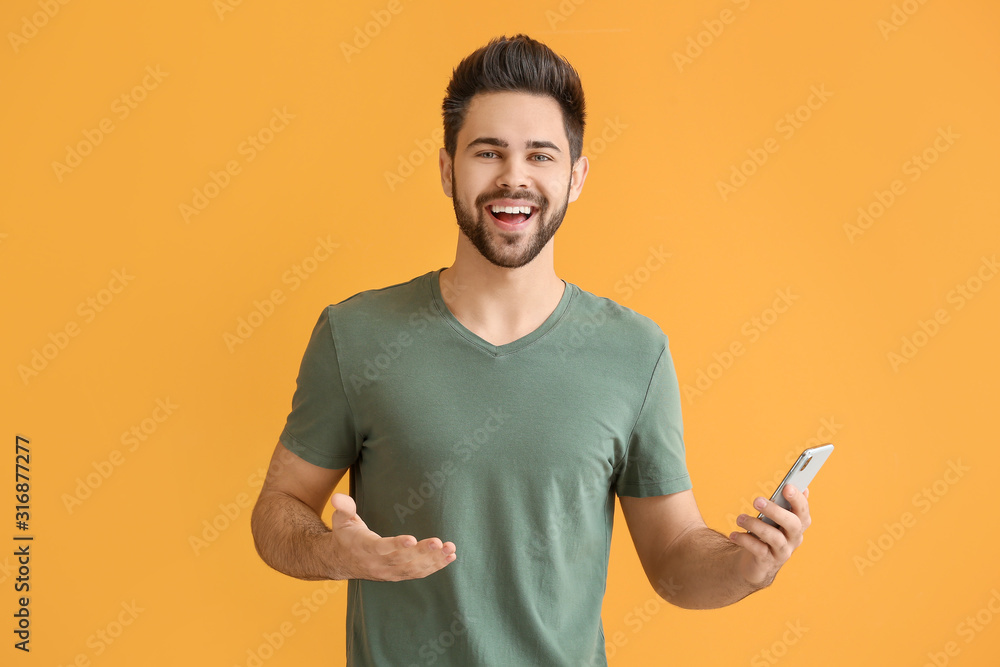 Happy young man with mobile phone on color background Happy young man with mobile phone on color background