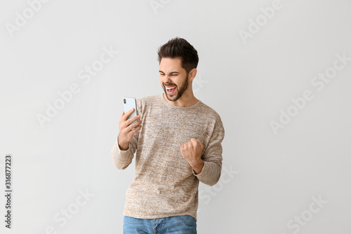 Happy young man with mobile...
